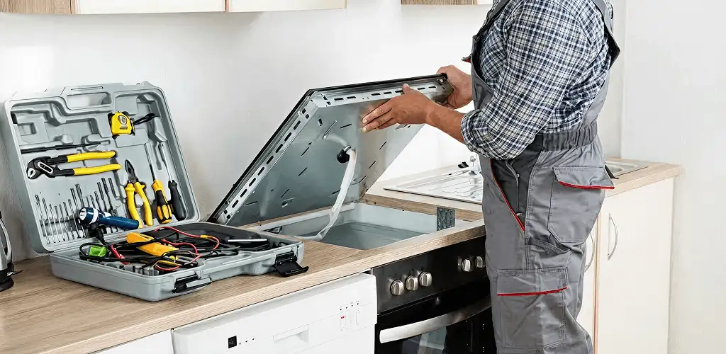 Handyman repairing a cooktop and checking wiring connections in Denver, CO