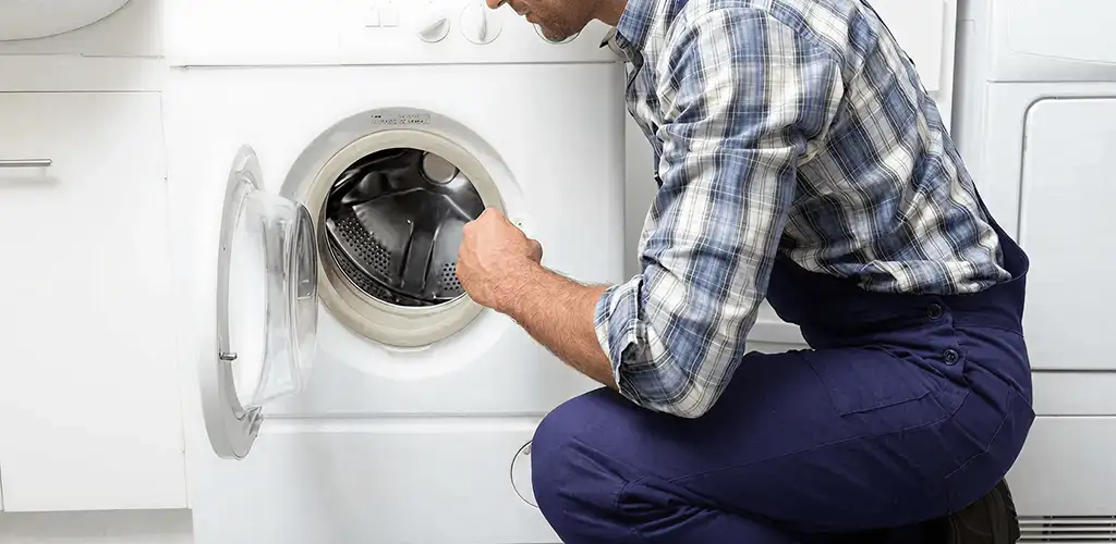 Handyman inspecting a dryer drum and internal parts for repair in Denver, CO