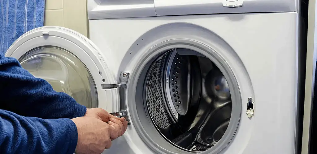 Washing machine repair handyman checking a front-load washer door and latch in Denver, CO