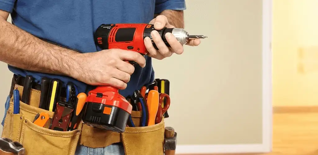 Handyman holding a power drill for home repairs and installations in Denver, CO
